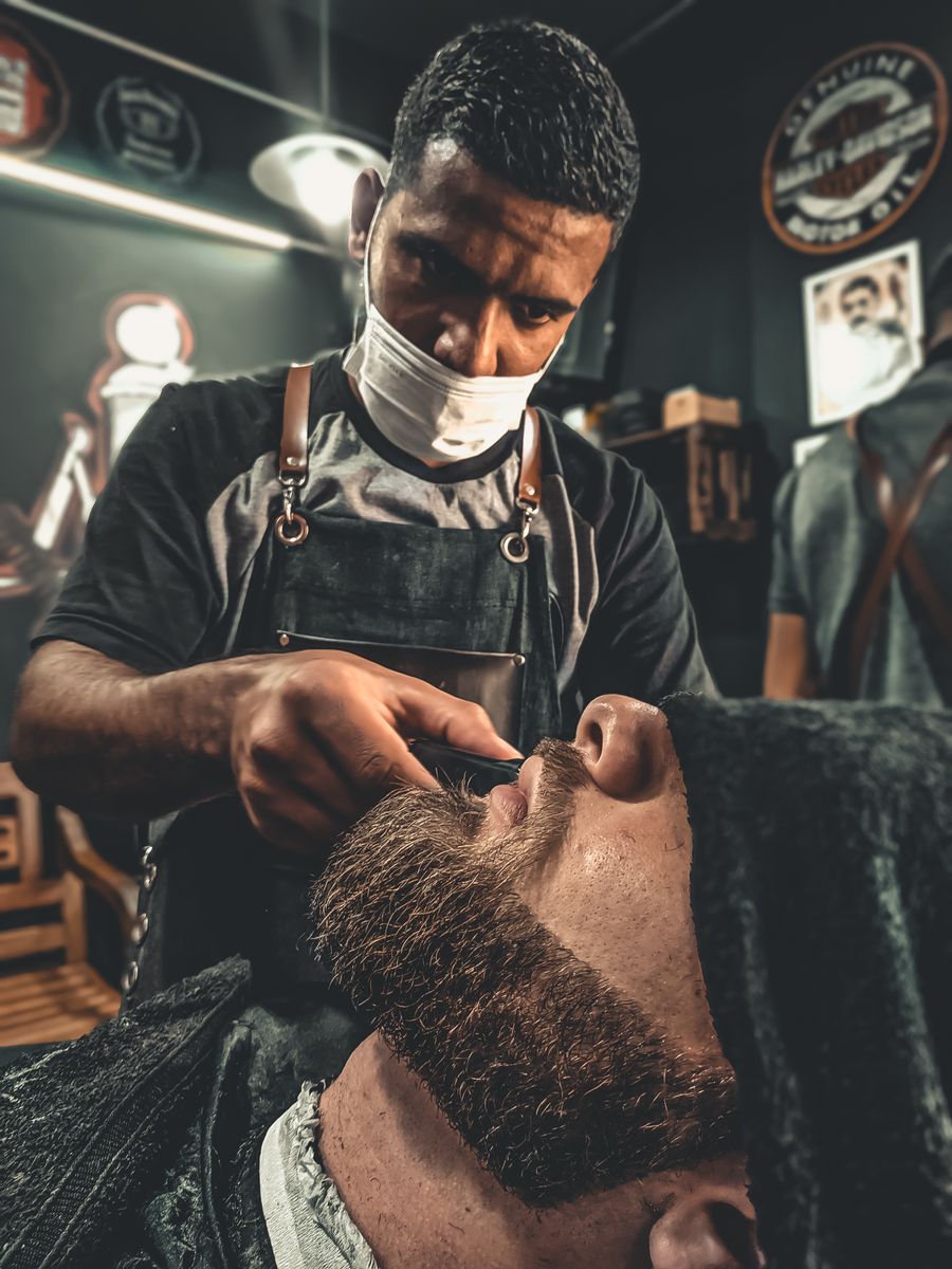 Barber trimming a client's beard